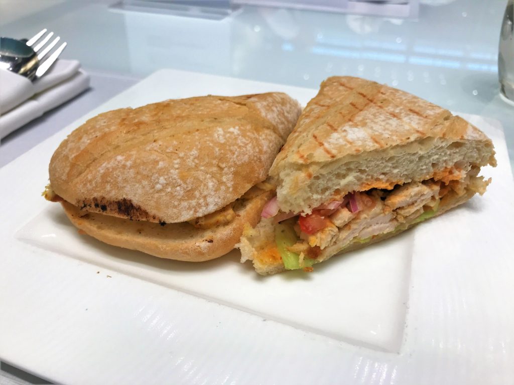 Qatar Airways Business Class Al Mourjan lounge Doha review chicken sandwich deli