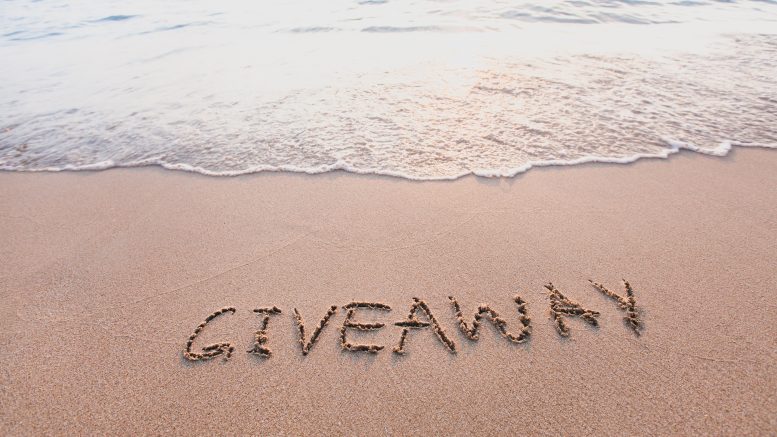 giveaway concept, word message written on the sand