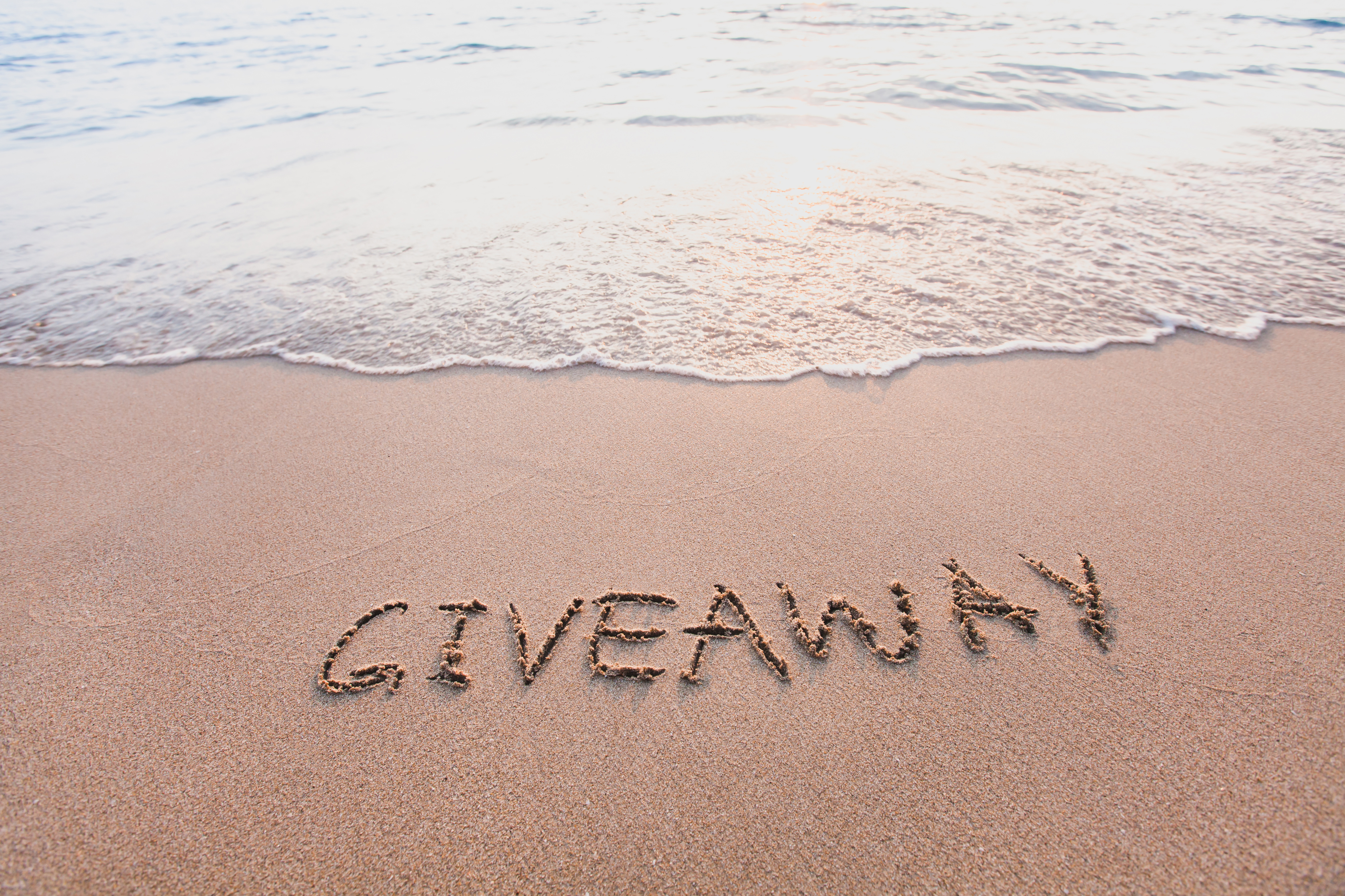 giveaway concept, word message written on the sand