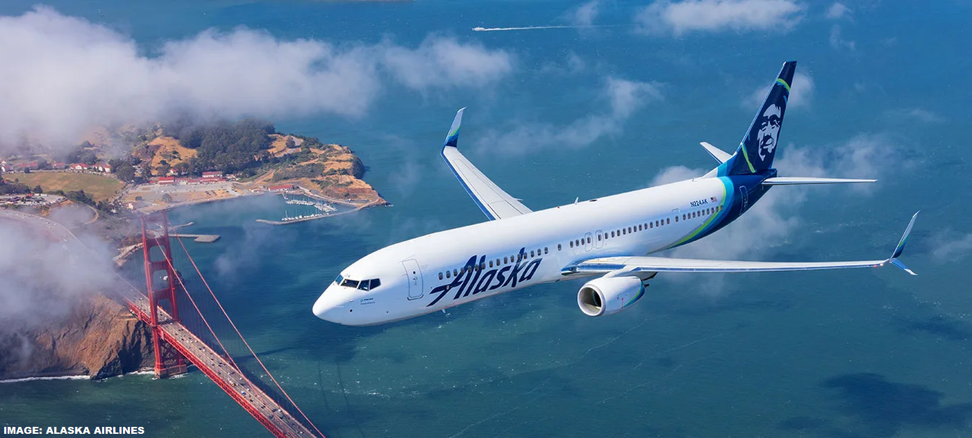 Alaska Airlines aircraft flying over a body of water.