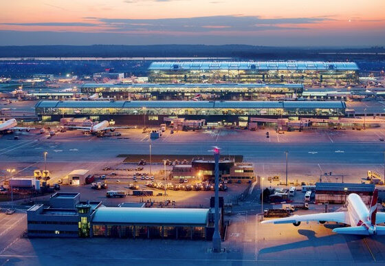 Heathrow Airport, Terminal 5 complex, T5A (top) T5B and T5C (centre), viewed from control tower at dusk, airfield operations base in lower foreground, March 2013.