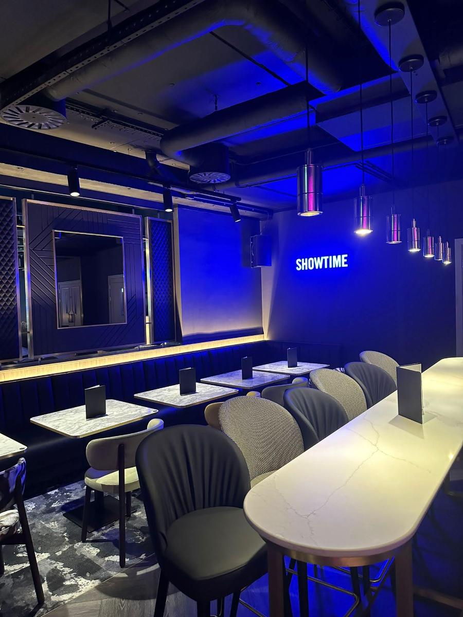 Tables and Chairs with the blue light showtime word on the wall